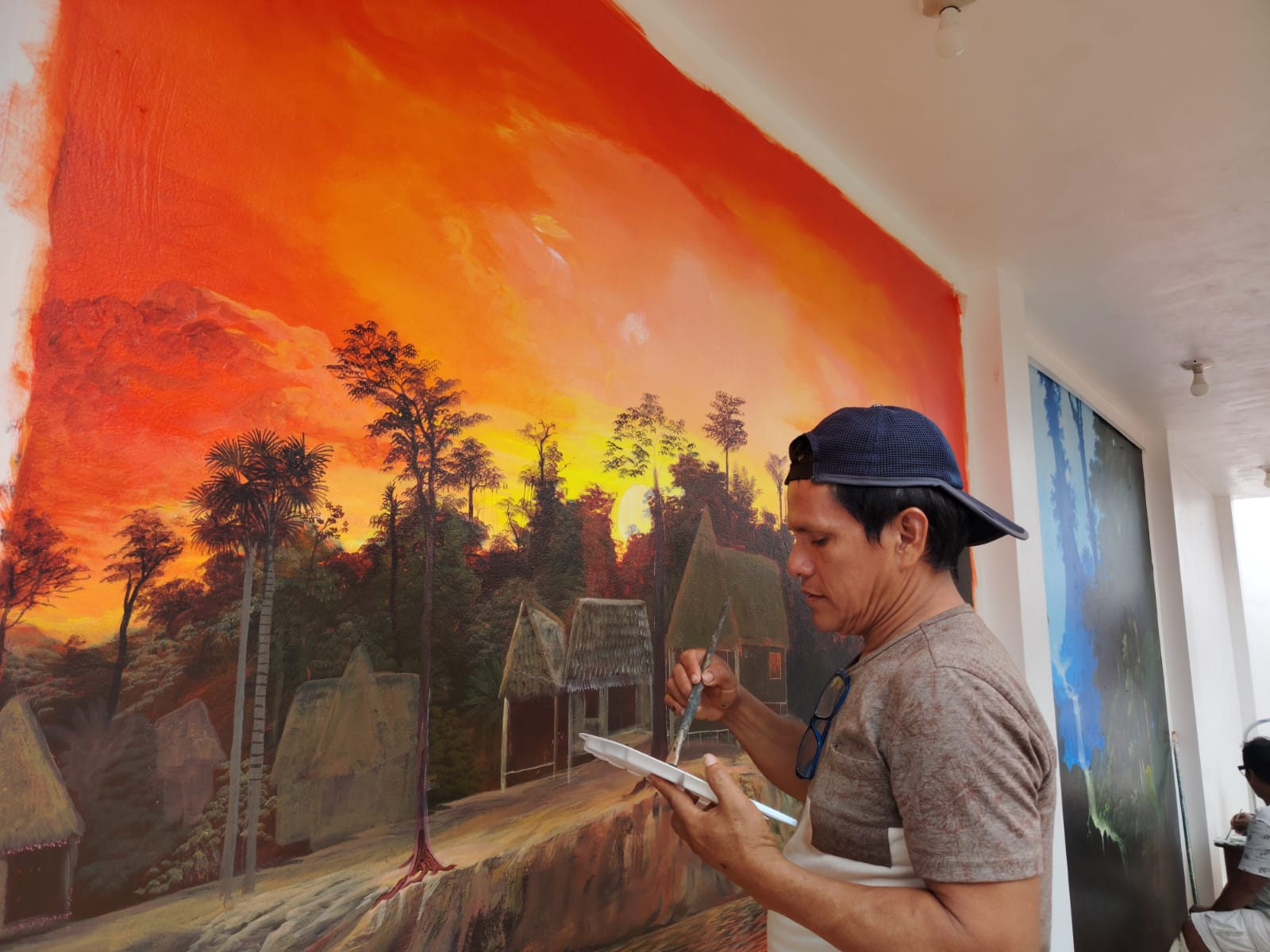 David Amaringo painting a large wall mural