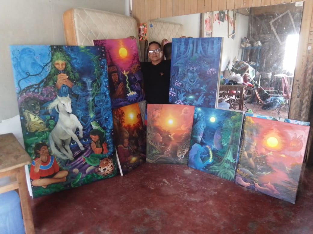 David Amaringo in his studio surrounded by his paintings